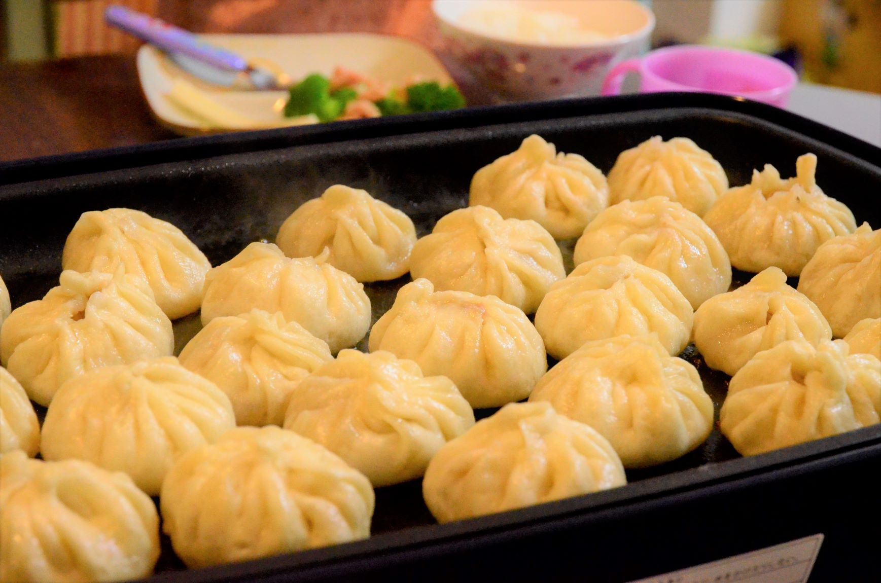 Roasted dumplings with plenty of gravy mass-produced on a hot plate